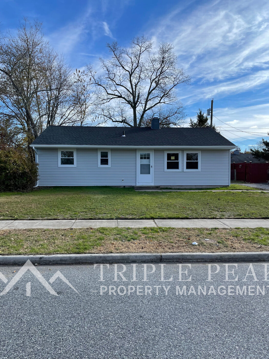 Single-family rental home with light siding and a front lawn